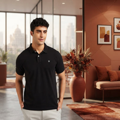 A South Asian man wearing a polo shirt in a modern office, styled with terracotta and burnt sienna accents.